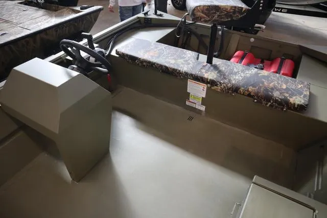 Slide: The Image of 2025 Lowe Roughneck 1860 Rambler boat interior with camouflage seating and steering console. - 22