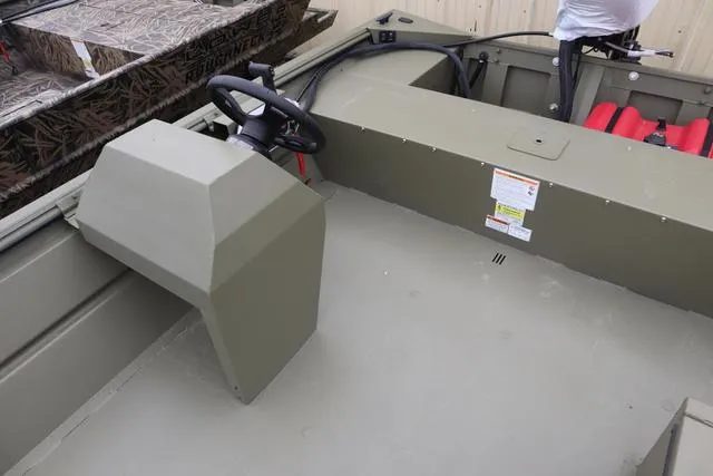 Slide: The Image of 2025 Lowe Roughneck 1860 Rambler boat interior with steering console and seating. - 4