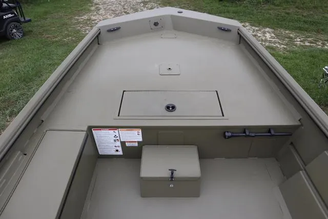 Slide: The Image of 2025 Lowe Roughneck 1860 Rambler boat interior with storage compartments, on grassy terrain. - 5