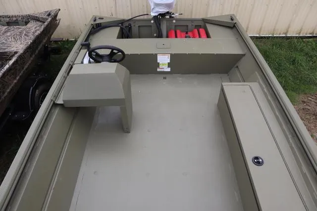 Slide: The Image of 2025 Lowe Roughneck 1860 Rambler boat interior with steering console and storage compartments. - 6