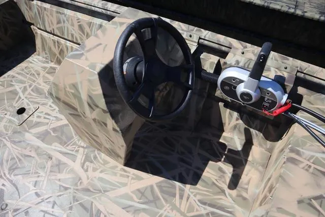 Slide: The Image of 2025 Lowe Roughneck 1760 console with camouflage design and steering wheel. - 5