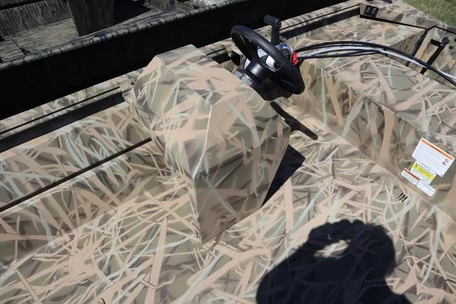Slide: The Image of 2025 Lowe Roughneck 1760 boat with camo console and steering wheel. - 7
