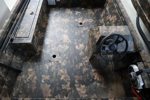 Slide: The Image of 2024 Lowe Roughneck 1760 boat interior with camo design and add-on console. - 6