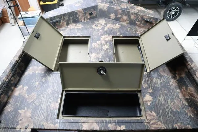 Slide: The Image of 2024 Lowe Roughneck 1760 boat with open storage compartments and camo design. - 7