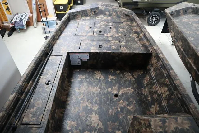 Slide: The Image of 2024 Lowe Roughneck 1760 boat interior with camo design and storage compartments. - 9