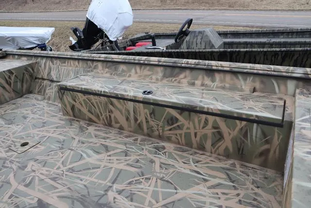 Slide: The Image of Camouflage-patterned Lowe 2070 boat with add-on console, 2025 model, parked outdoors. - 12