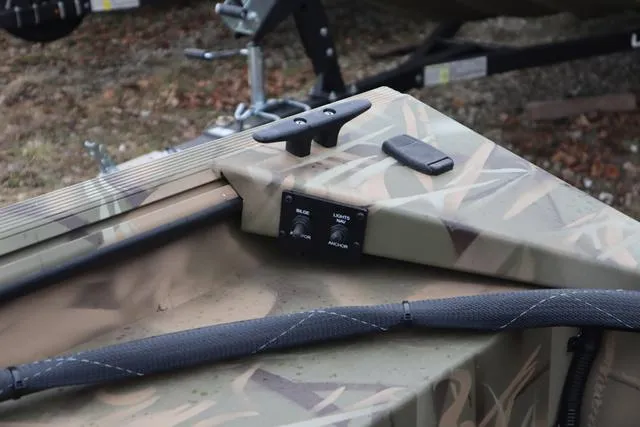 Slide: The Image of 2025 Lowe 2070 boat with add-on console, featuring camouflage design and control switches. - 15