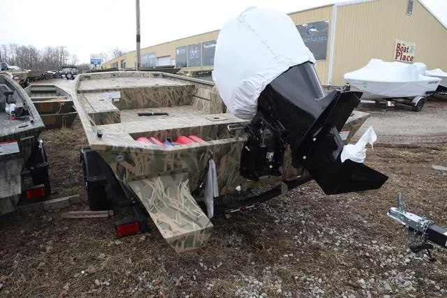 Slide: The Image of 2025 Lowe 2070 boat with add-on console, camo design, parked outdoors. - 3