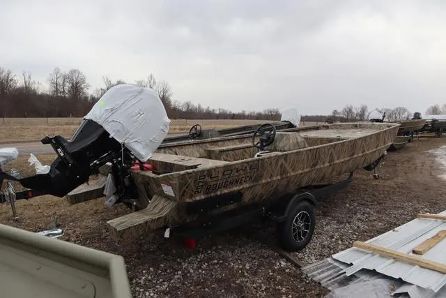 Slide: The Image of Lowe 2070 boat with add-on console, 2025 model, parked outdoors on a cloudy day. - 4