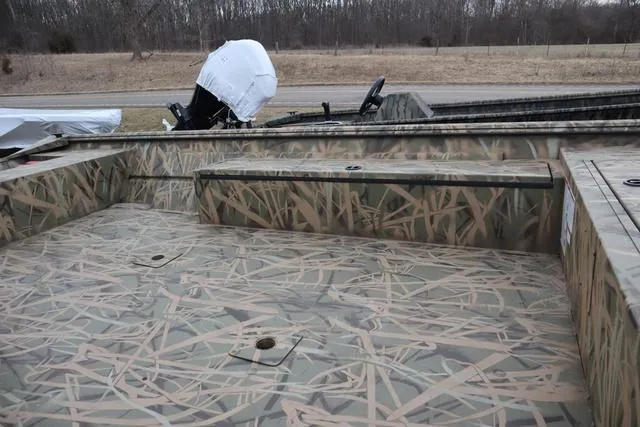 Slide: The Image of 2025 Lowe 2070 boat with add-on console, camo interior, parked outdoors. - 6