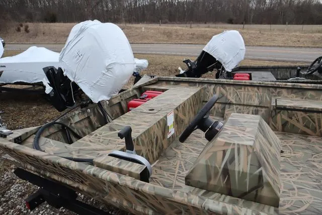 Slide: The Image of 2025 Lowe 2070 boat with add-on console, camo design, parked outdoors. - 7