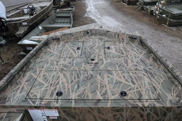 Slide: The Image of 2025 Lowe 2070 boat with camo design and add-on console, parked on gravel. - 8