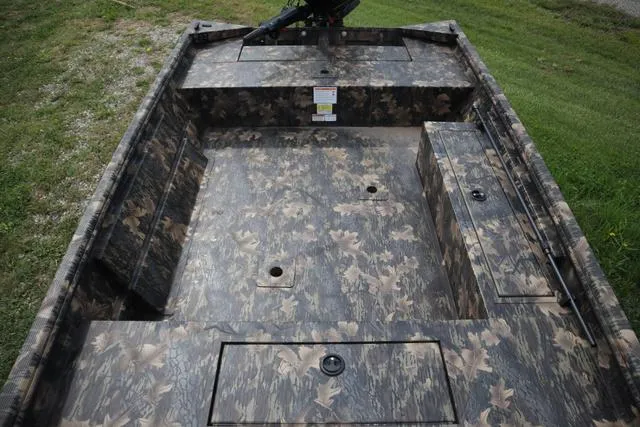 Slide: The Image of 2024 Lowe Roughneck 1660 Tiller boat interior with camouflage design, featuring storage compartments. - 8