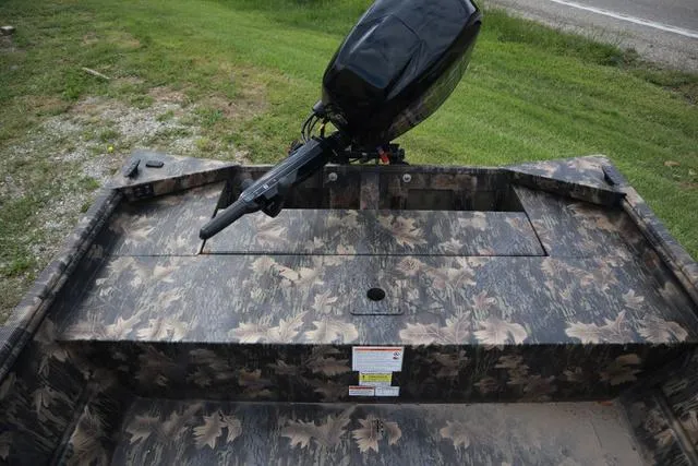 Slide: The Image of 2024 Lowe Roughneck 1660 Tiller boat with camouflage design and outboard motor. - 9