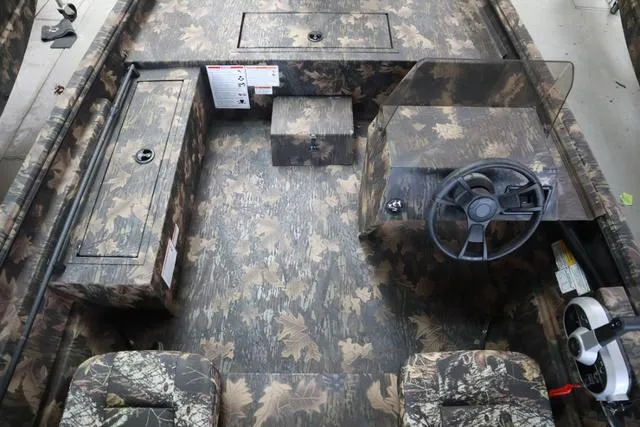 Slide: The Image of 2024 Lowe Roughneck 1760 SC Jet boat interior with camouflage design and steering console. - 4