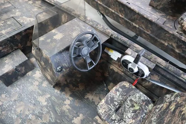 Slide: The Image of 2024 Lowe Roughneck 1760 SC Jet boat interior with camouflage design and steering console. - 6