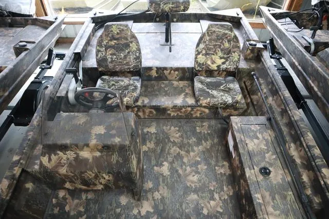 Slide: The Image of 2024 Lowe Roughneck 1760 SC Jet boat interior with camouflage seating and flooring. - 8
