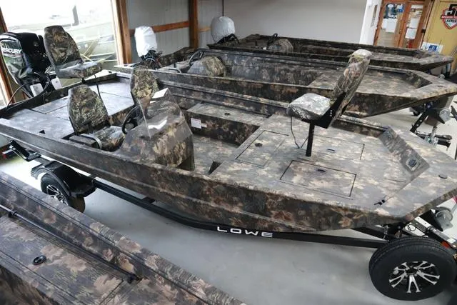 Slide: The Image of 2024 Lowe Roughneck 1760 SC Jet boat with camouflage design in showroom. - 9