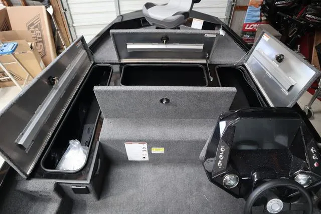 Slide: The Image of 2025 Crestliner XF 17 BASS boat interior with open storage compartments and steering console. - 7
