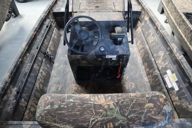 Slide: The Image of 2024 Lowe Roughneck 1860 CC boat interior with camouflage design and steering console. - 3