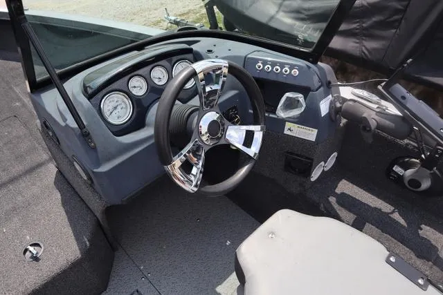 Slide: The Image of 2016 Lowe FM 1710 Pro WT boat dashboard with steering wheel and gauges. - 5
