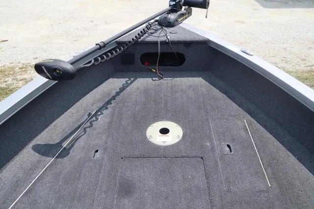 Slide: The Image of 2016 Lowe FM 1710 Pro WT boat deck with trolling motor and carpeted surface. - 6