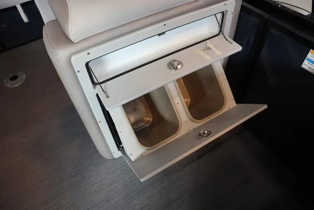 Slide: The Image of 2025 Godfrey Sweetwater 2286 SFL boat interior storage compartment with beige upholstery. - 10