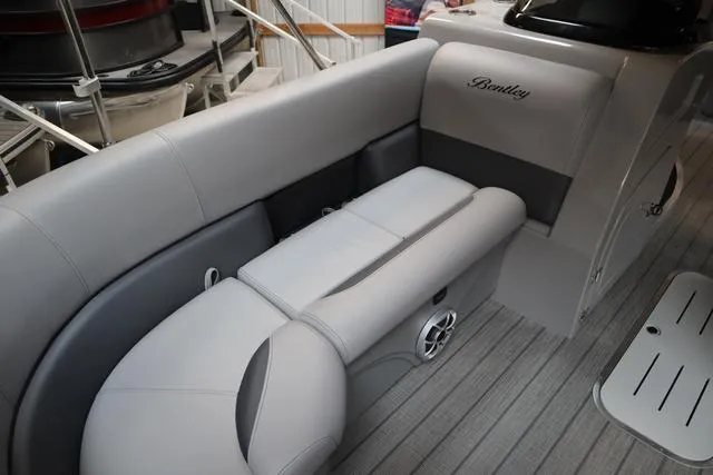 Slide: The Image of 2025 Bentley Pontoons Legacy 243 Swingback interior with gray seating and speaker system. - 27