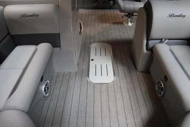 Slide: The Image of 2025 Bentley Pontoons Legacy 243 interior with gray seating and floor speakers. - 28