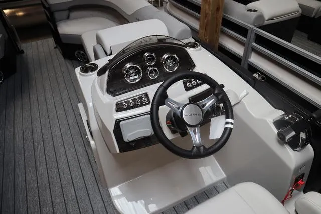 Slide: The Image of 2023 Lowe SS 210 Triple Tube Package boat dashboard with steering wheel and controls. - 4