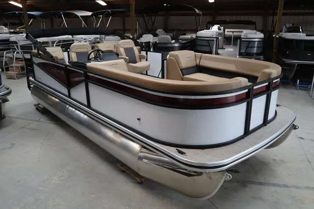 Slide: The Image of 2025 Lowe LS 210 WT pontoon boat in showroom, featuring beige seating and sleek design. - 1