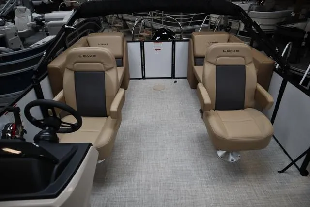 Slide: The Image of 2025 Lowe LS 210 WT boat interior with beige seating and steering wheel. - 4