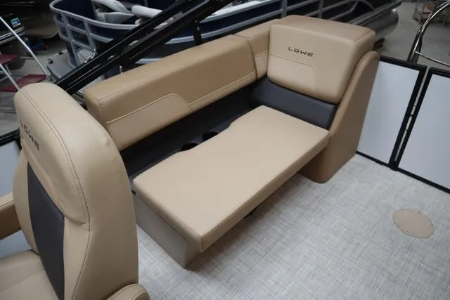 Slide: The Image of 2025 Lowe LS 210 WT boat interior with beige seating and cup holders. - 5