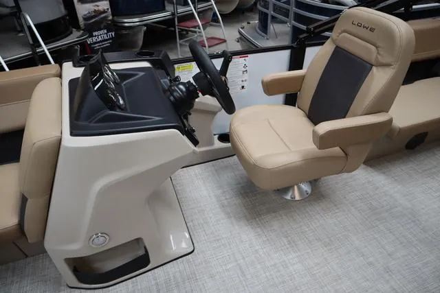 Slide: The Image of 2025 Lowe LS 210 WT boat interior with beige captain's chair and steering console. - 6