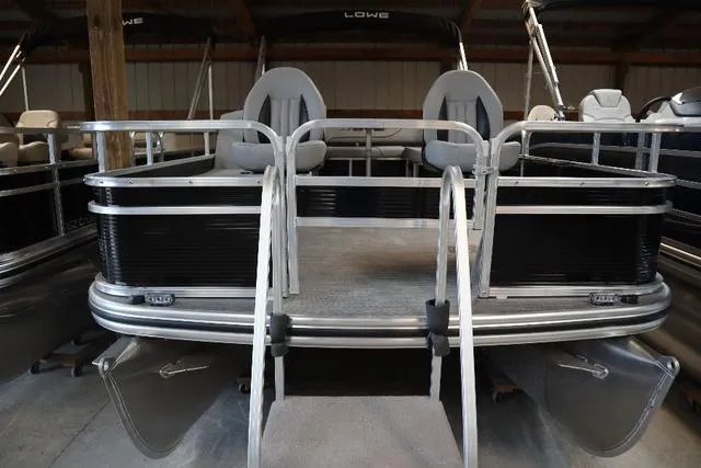 Slide: The Image of 2023 Lowe Ultra Fish 182 pontoon boat with dual seating, docked indoors. - 9