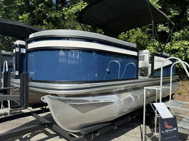 Slide: The Image of 2025 Lowe LS 190 pontoon boat with blue exterior and canopy, displayed outdoors. - 8