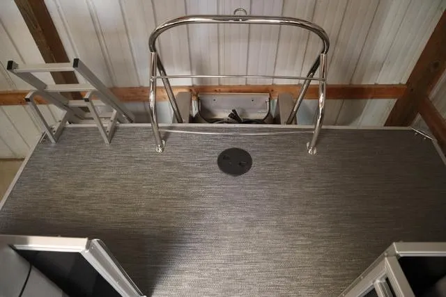 Slide: The Image of 2024 Godfrey Sweetwater 2286 SB Triple Tube Back Porch with ladder and railing in a garage. - 17