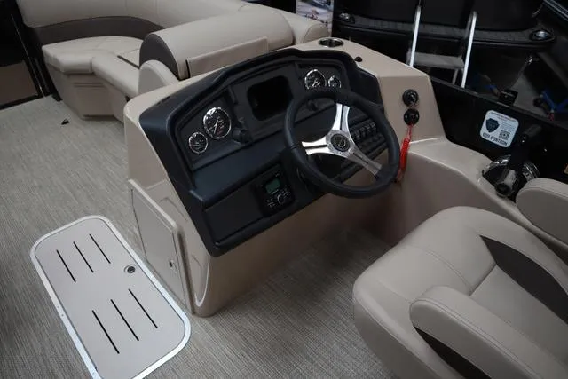 Slide: The Image of 2025 Bentley Pontoons Legacy 223 Navigator Sport Tube helm with modern controls and beige seating. - 6
