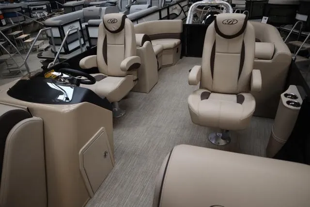 Slide: The Image of 2024 Bentley Pontoons Legacy 220 Navigator interior with luxurious beige seating and modern helm. - 17