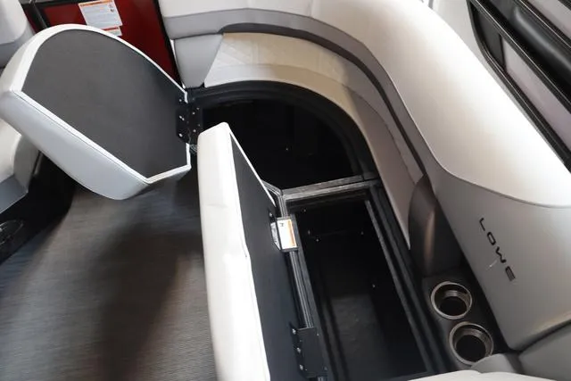 Slide: The Image of 2025 Lowe SS 230 WV boat interior with open storage compartment and cup holders. - 14