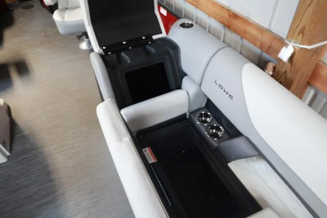 Slide: The Image of 2025 Lowe SS 230 WV boat interior with open storage and cup holders. - 16