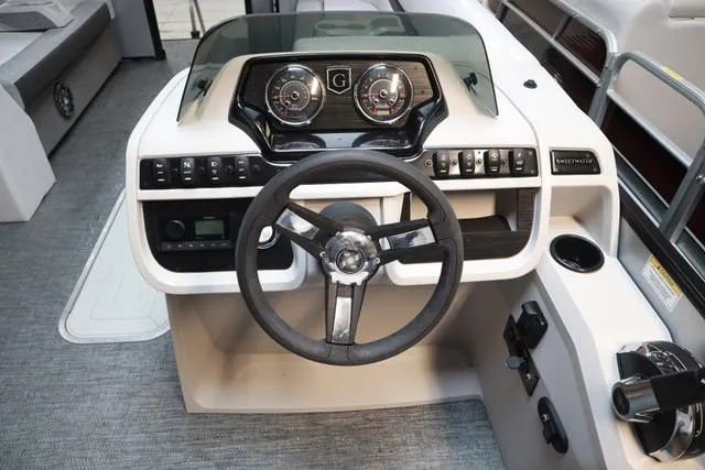 Slide: The Image of 2024 Godfrey Sweetwater 2286 SFL boat dashboard with steering wheel and control panel. - 11