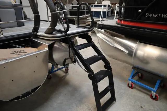 Slide: The Image of 2025 Bentley Pontoons Elite 253 Swingback Triple Tube, docked with visible ladder and pontoons. - 13