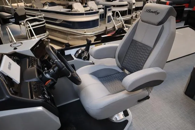 Slide: The Image of 2025 Bentley Pontoons Elite 253 Swingback Triple Tube Pkg captain's chair and helm. - 17
