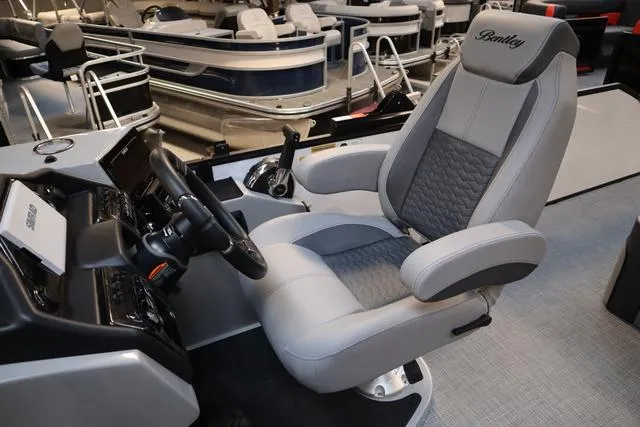 Slide: The Image of 2025 Bentley Pontoons Elite 253 Swingback helm seat, luxurious design, and modern controls. - 29