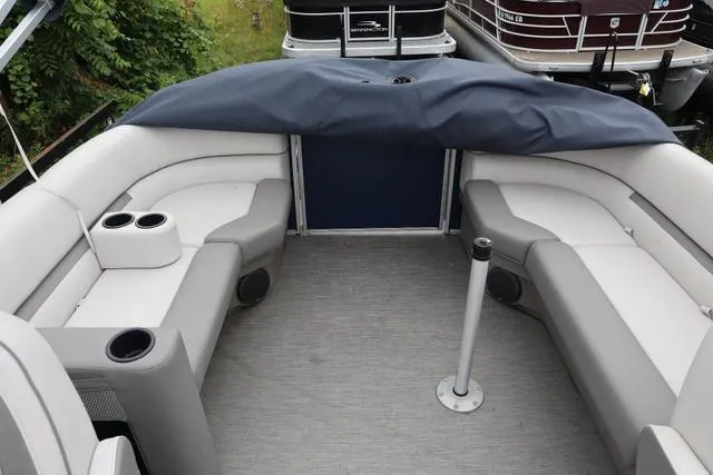 Slide: The Image of 2022 Sweetwater 2286SBX pontoon boat interior with gray seating and cup holders. - 6