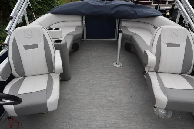 Slide: The Image of 2022 Sweetwater 2286SBX boat interior with gray seating and cup holders. - 9