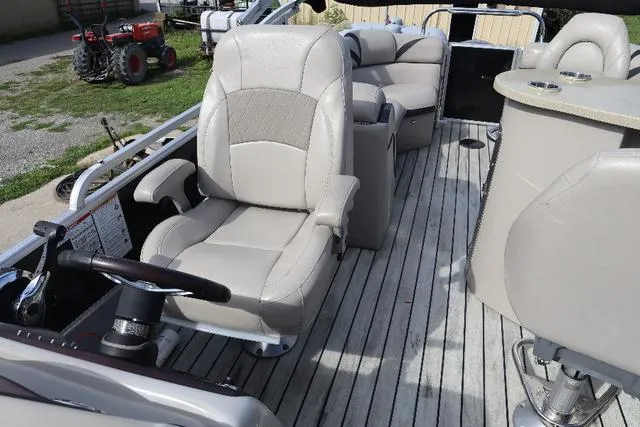 Slide: The Image of 2017 Berkshire 23 E STS boat interior with beige seating and steering wheel. - 4