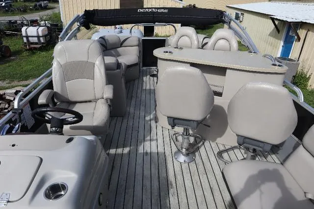 Slide: The Image of 2017 Berkshire 23 E STS pontoon boat interior with beige seating and helm. - 7