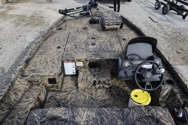 Slide: The Image of 2024 Lowe Stinger 175 Poly Camo boat interior with camouflage design and steering console. - 5